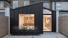 a small black house with an open roof