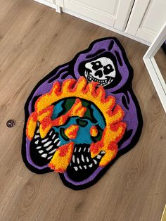 a colorful rug with a skull and flames on the floor next to a white cabinet