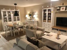 a living room filled with furniture and a flat screen tv sitting on top of a wooden table