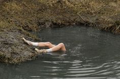 a man laying in the water with his legs up