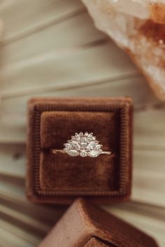 an engagement ring sits in a velvet box