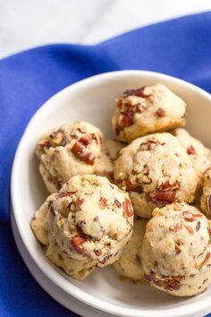 a white bowl filled with cookies on top of a blue cloth