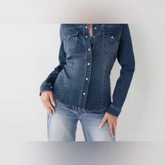 The Western Denim Shirt Is A True Classic. This Long Sleeve Women's Denim Shirt Features A Classic Collared, Button Down Design. Finished With A Western Style Yoke, Pearlized Snaps, And Chest Patch Pockets With Our Signature Horseshoe Stitching. Washed Blue Denim Top With Button Closure, Button-up Denim Tops With Snap Buttons, Fitted Denim Shirt With Button Closure, Fitted Washed Blue Tops With Snap Buttons, Denim Blue Button-up Top With Snap Buttons, Dark Wash Denim Button-up Top With Snap Buttons, Denim Button-up Top With Snap Buttons, Fitted Dark Wash Denim Button-up Top, Medium Wash Denim Shirt With Snap Buttons