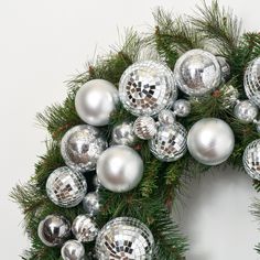 a christmas wreath made out of shiny silver balls