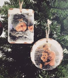 two ornaments hanging from a christmas tree with an ornament shaped like a baby's head