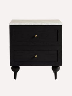 a black and white nightstand with two drawers on wheels, one drawer has marble top