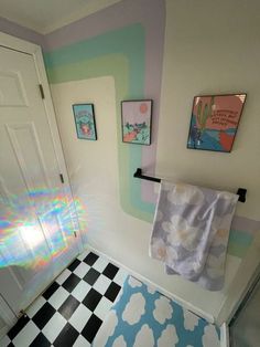 a bathroom with a checkered floor and colorful wall paper on the shower curtain rod