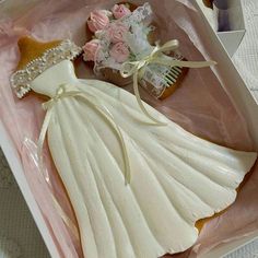 a cookie shaped like a bride's dress in a box