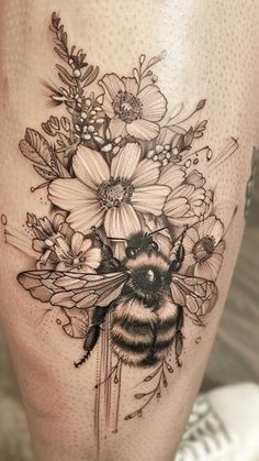 a black and white photo of a bee with flowers on it's side thigh