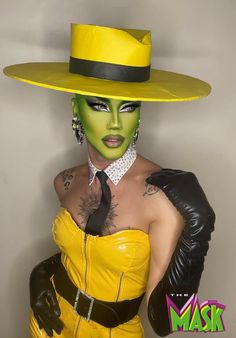 a woman wearing a yellow hat and green makeup