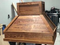 a wooden stove top sitting on top of a table in a room filled with tools