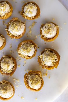 small pastries are arranged on a white platter with crumbs scattered around them