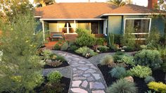 a house with landscaping in the front yard and walkway leading up to it's entrance