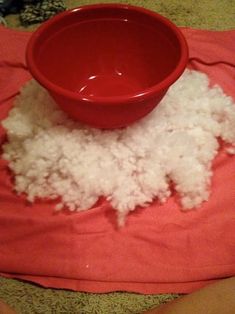 a red bowl sitting on top of a pile of white rice next to a pink towel