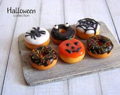 a wooden tray topped with donuts covered in frosting and sprinkles