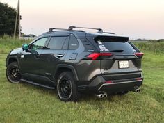 the rear end of a gray toyota rav parked in a field