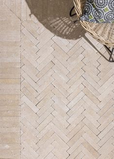 a wicker chair sitting on top of a stone floor