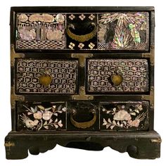 an old wooden chest with many drawers on it's sides and designs painted on the front