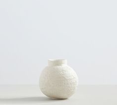 a white vase sitting on top of a table