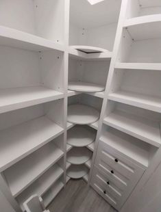 an empty white closet with shelves and drawers