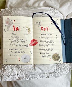 an open notebook with writing on it and magnets attached to the pages, sitting on a bed