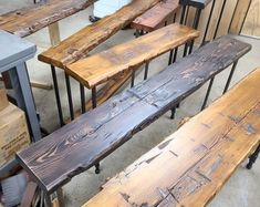 several wooden benches sitting next to each other on top of a cement floor in a room