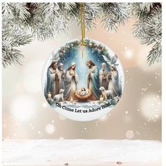 a christmas ornament hanging from a tree with the nativity scene on it