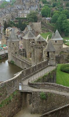 an aerial view of a castle with water in the foreground and buildings on the other side