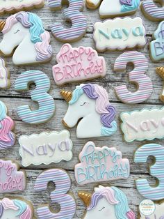 decorated cookies with unicorns and numbers on wooden background for birthday party or baby's first birthday