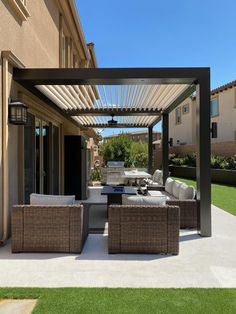 an outdoor living area with wicker couches and chairs under a pergolated roof