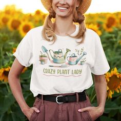 Introducing the "Crazy Plant Lady With Gardening Tools" t-shirt from Kooskadoo – the perfect gift for the green-thumbed goddess in your life! Crafted from premium Bella-Canvas fabric, this unisex tee is as soft and comfortable as it is stylish. With its playful yet chic design, featuring the words "Crazy Plant Lady" alongside charming gardening tools, this shirt is sure to delight any plant enthusiast. Whether she's tending to her beloved houseplants, cultivating a lush garden oasis, or simply e Short Sleeve T-shirt With Plants Print For Gardening, Graphic Tee Crew Neck T-shirt, Cotton Graphic Print T-shirt For Gardening, Cotton T-shirt With Graphic Print For Gardening, Spring Crew Neck T-shirt For Outdoor, Spring Short Sleeve T-shirt For Gardening, Cotton T-shirt For Gardening In Summer, Relaxed Fit T-shirt For Gardening In Spring, Green T-shirt With Plant Print For Gardening