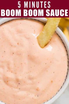 a white bowl filled with sauce and a piece of bread sticking out of the top