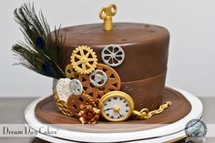 there is a chocolate cake decorated with gears and feathers on the top, as well as a peacock