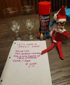 an elf is sitting on the table next to some wine glasses and a note that says, let's make a haze cloud