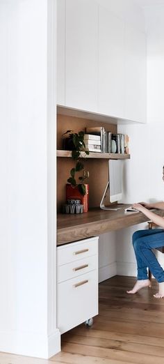 a woman sitting at a desk with her feet up on the table and working on a computer