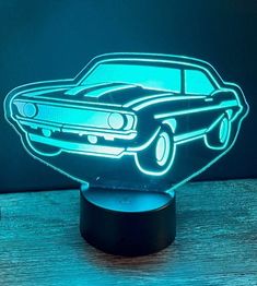 a car is shown in the shape of a night light on a wooden table with a dark background