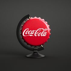 a red bottle cap with the word coca - cola on it sitting on top of a black stand