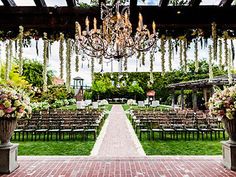 an outdoor ceremony setup with chandelier and chairs