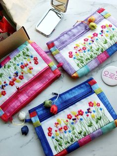 two bags are sitting on a table next to some sewing supplies