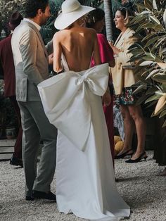 a woman in a white dress standing next to a man