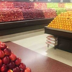 an empty grocery store filled with oranges and apples