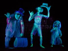 three children are dressed up in glow costumes