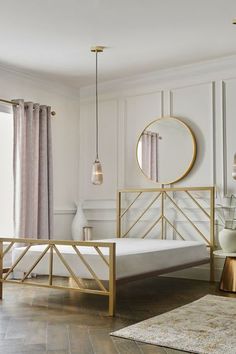 a bed room with a neatly made bed and a round mirror