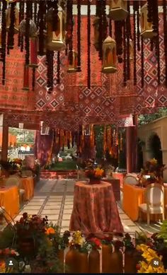 the inside of a building decorated in orange and red colors with hanging decorations on the ceiling