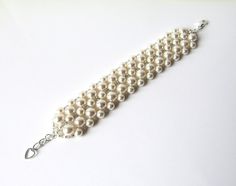 A timeless bracelet completely hand-woven in your choice of Swarovski white (shown in pictures) or ivory/cream pearls and tiny antique silver Japanese seed beads. ~1/2 INCH EXTENSION INCLUDED ~ For adjustable sizing, embellished with silver heart charm~Width Approximately 1.25 inches~♥ All jewelry comes in a gift box and is ready to give, at no additional cost! ♥------::BRACELET SIZE::X Small - 6.5" ~ expands toSmall - 7" ~ expands to 7.5"Standard - 7.5" ~ expands to 8"Large - 8" ~ expands to 8. Classic White Wedding Bracelets, Classic White Bracelets For Wedding, Cream Beaded Bracelets For Wedding, White Jubilee Beaded Bracelet For Wedding, White Beaded Jubilee Bracelet For Weddings, White Pearl Beaded Bracelet For Wedding, Cream Wedding Bracelet Jewelry, Cream Pearl Bracelet With Round Beads For Wedding, Cream Beaded Bracelets With Round Beads For Wedding