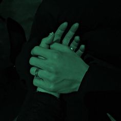 two hands holding each other in the dark