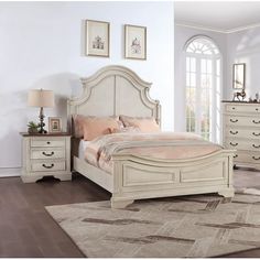 a white bed sitting in a bedroom on top of a wooden floor