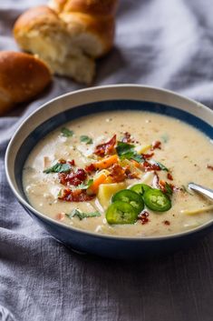 a bowl of soup with bread in the background