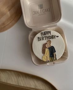 a cake in a box with a happy birthday design on it's side and an image of a man and woman holding each other