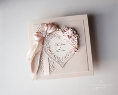 a wedding card with a heart and flowers on it's front, attached to a wall